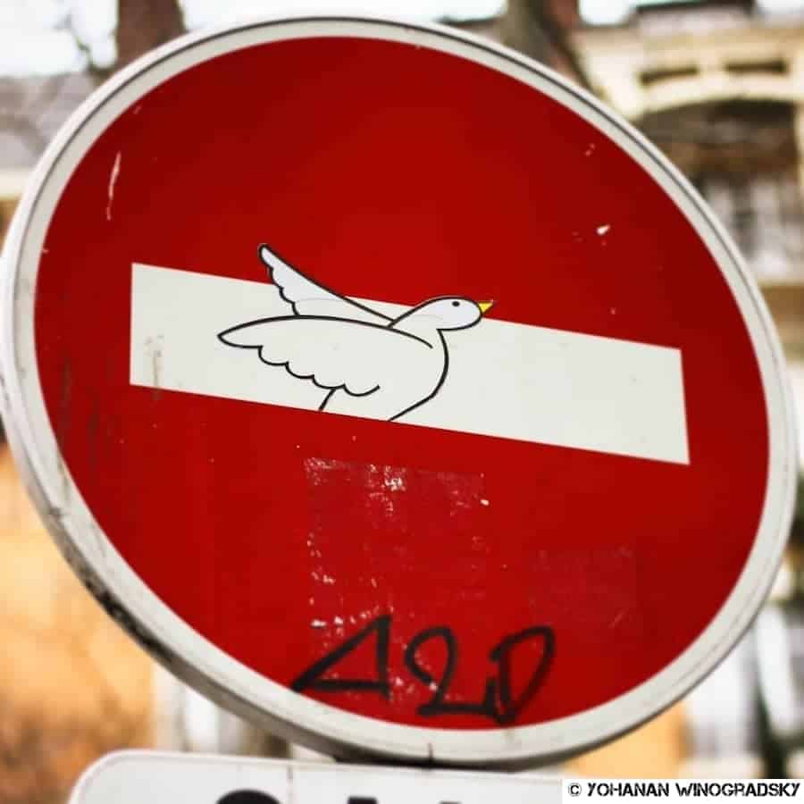 street art paris par clet abraham, panneau de sens interdit avec envol d'un oiseau