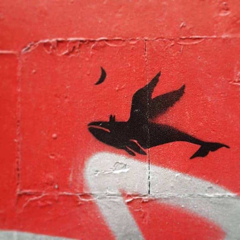 street art paris anonyme pochoir d'une baleine ailée s'envolant vers la lune